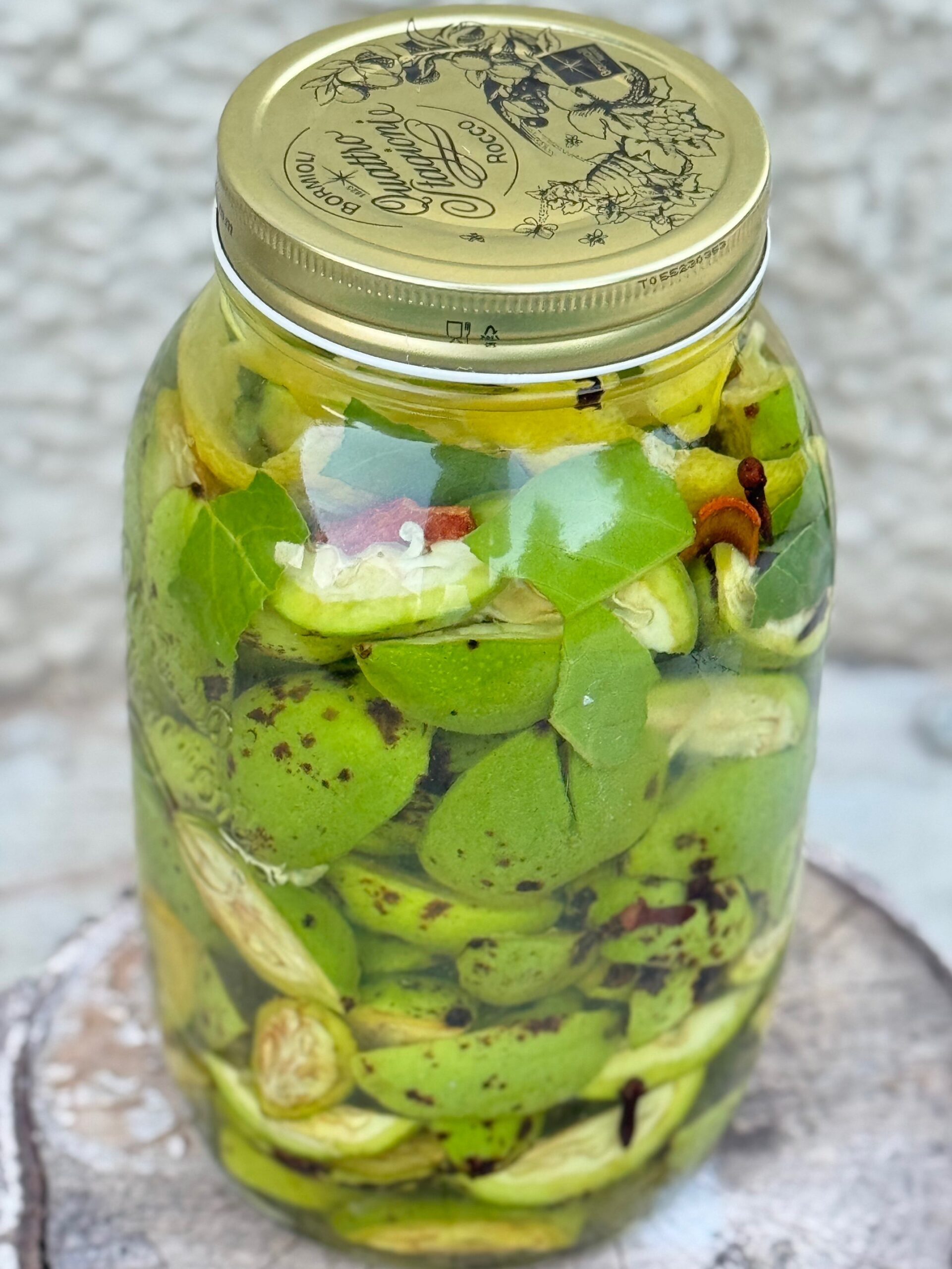 barattolo con infusione di alcool noci verdi e spezie