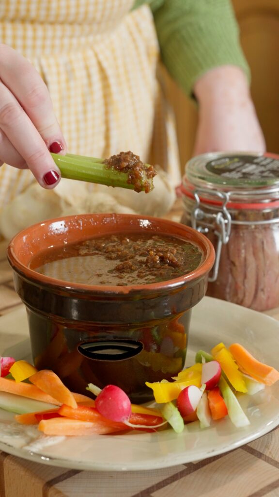 bagna cauda in un piatto da portata di coccio con verdure per servire