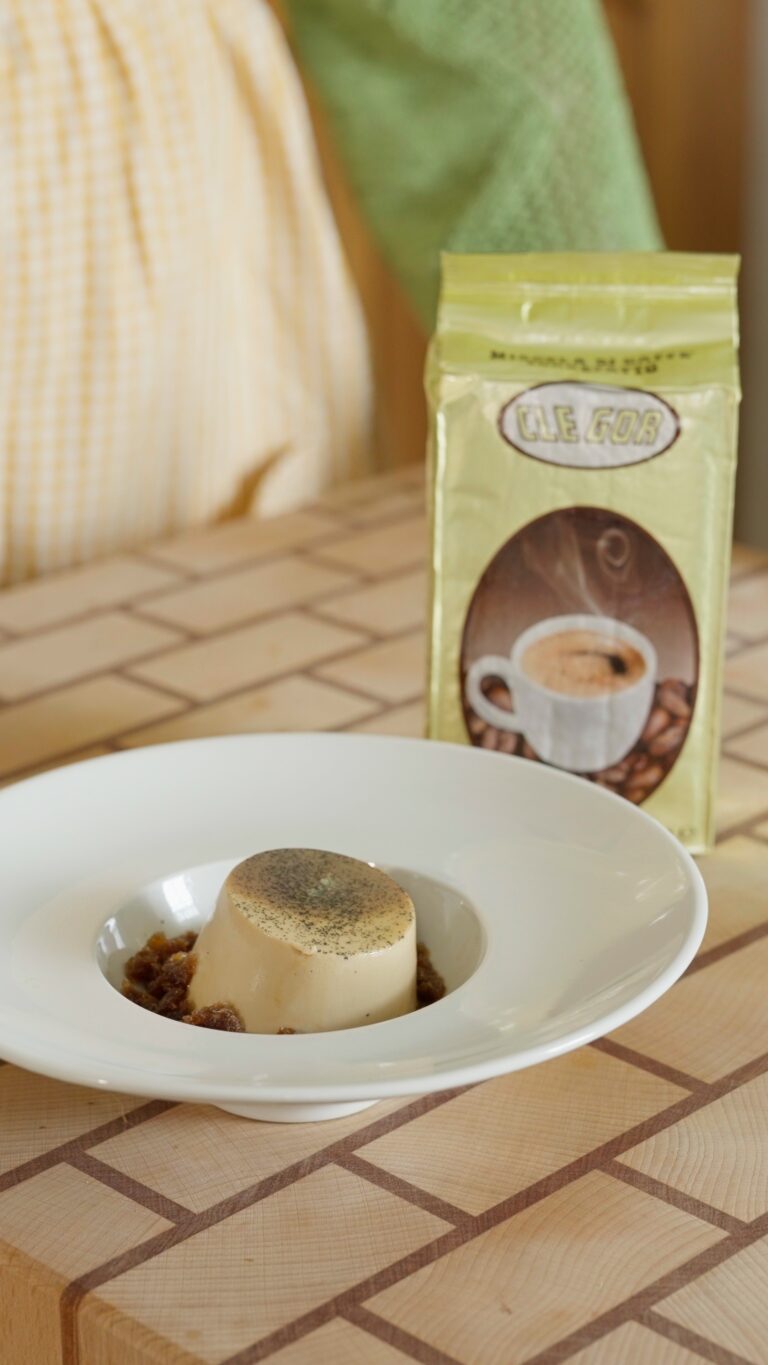 PANNA COTTA AL CAFFE CON GRANITA DI CAFFE IN PIATTO BIANCO SU TAVOLA DI LEGNO