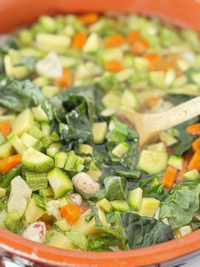 pentola di minestrone con un cucchiaio di legno