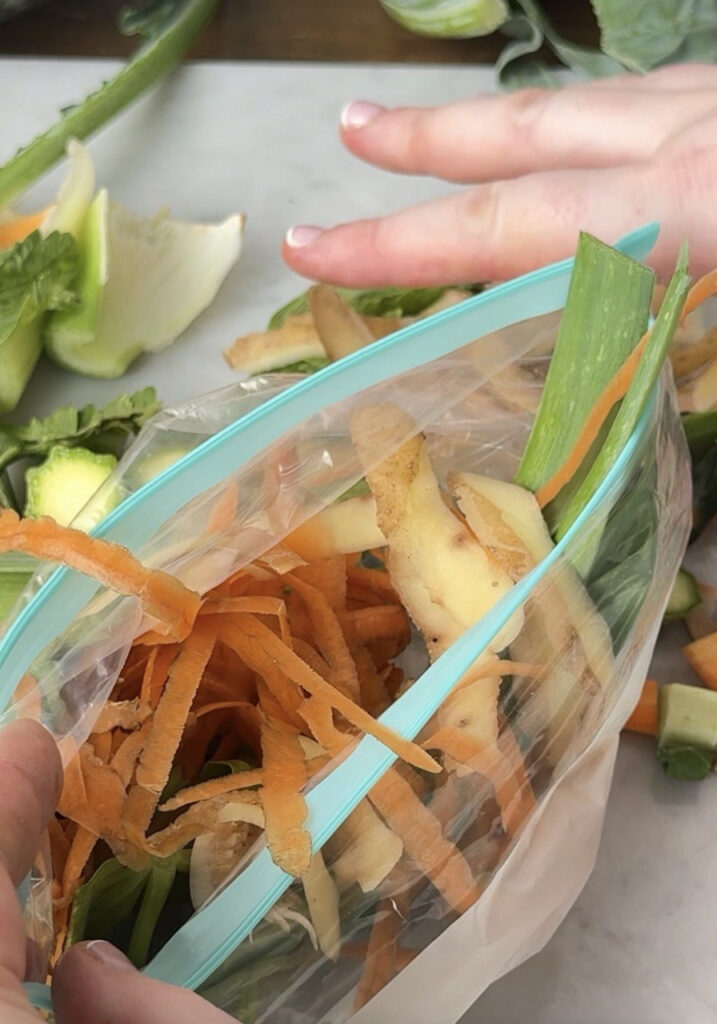 scarti di verdure in una busta di plastic, una mano la regge