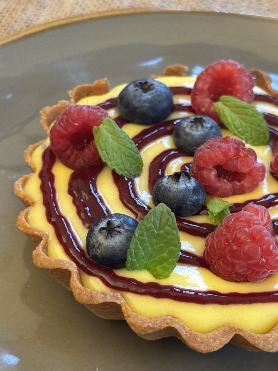 tartelletta con lemon curd e frutti di bosco su un piatto
