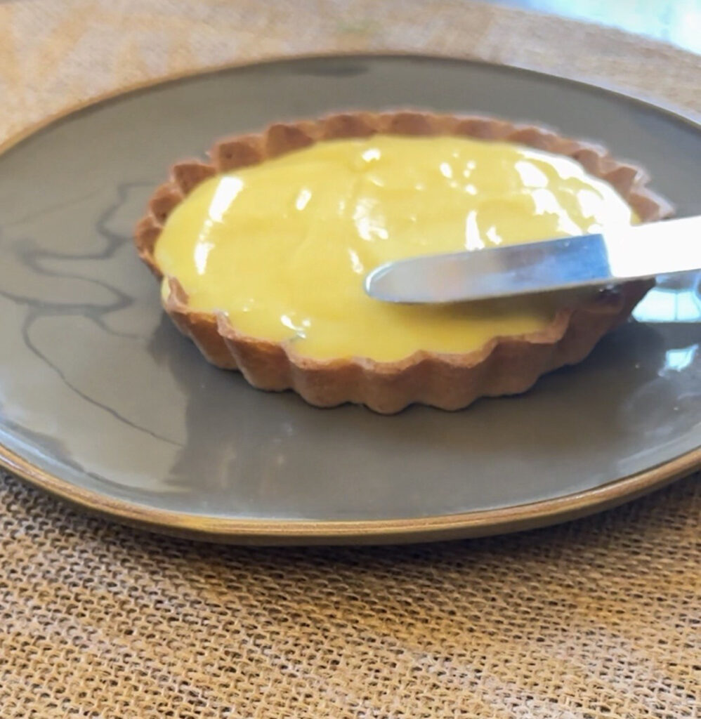 tartelletta su un piatto, coltello che stende